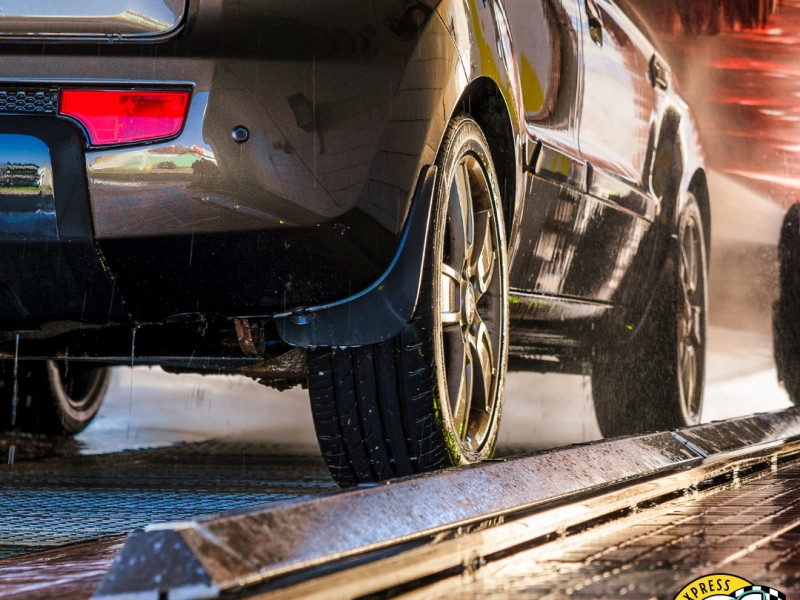 Car being washed in tunnel, focusing on the wheels going through with a ZIPS Car Wash logo in the lower-right corner